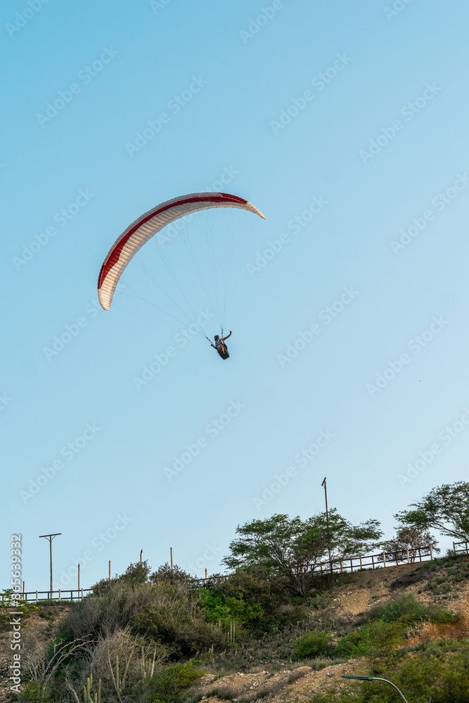 Paragliders in the sky. Man paragliding in a blue sky, on Cerro el Morro from Lechería, Venezuela Paragliders in the sky. Man paragliding in a blue sky, on Cerro el Morro from Lechería, Venezuela