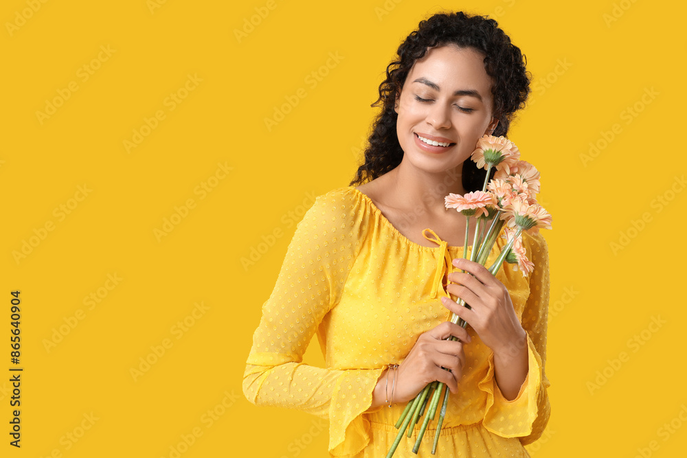 Beautiful young African-American woman with bouquet of gerbera flowers on yellow background. International Women's Day Beautiful young African-American woman with bouquet of gerbera flowers on yellow background. International Women's Day