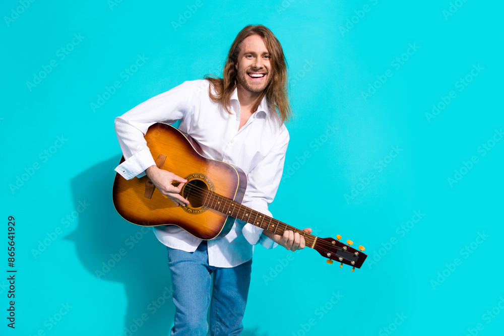 Photo of attractive funny guy wear white shirt playing guitar emtpy space isolated blue color background Photo of attractive funny guy wear white shirt playing guitar emtpy space isolated blue color background