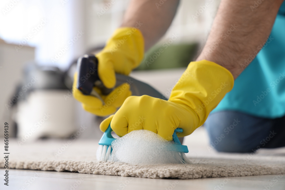 Male janitor cleaning carpet with brush in room, closeup Male janitor cleaning carpet with brush in room, closeup