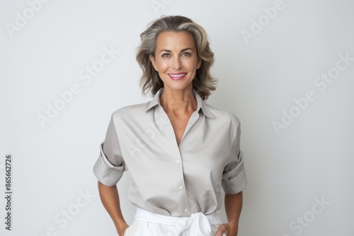 Portrait of beautiful happy gorgeous 50s mid age elderly modern woman with short haircut in white blouse. Copy space.