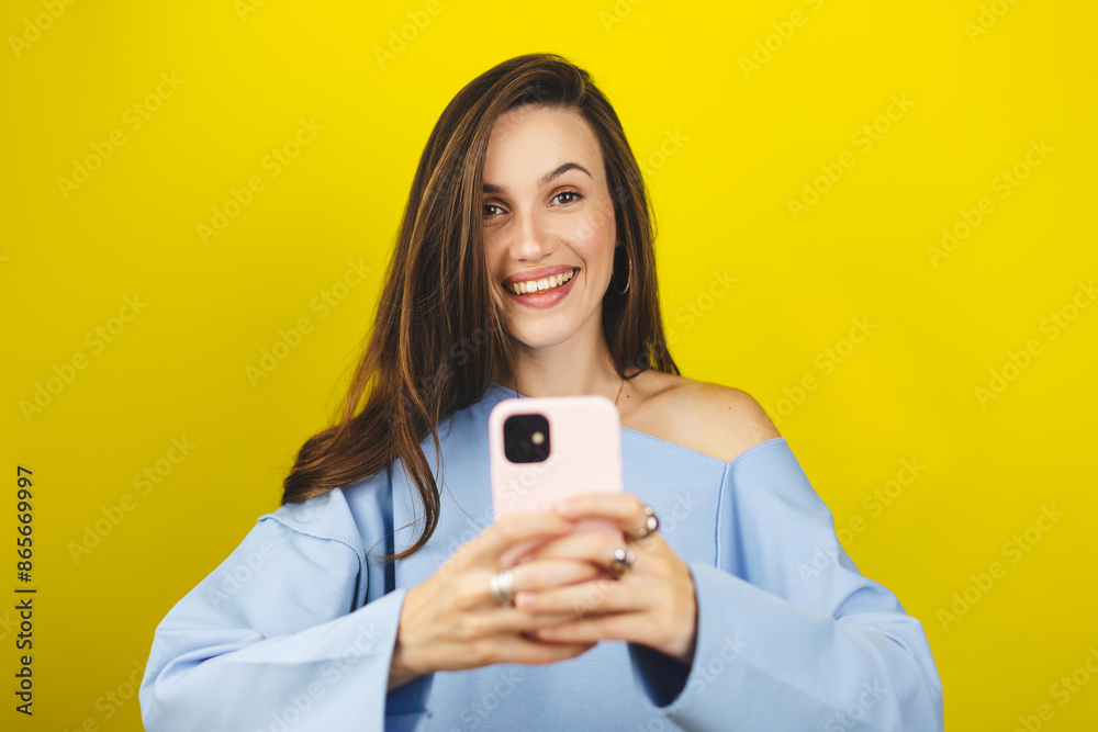 Overjoyed happy excited woman say wow, glad to receive text message informing about salary, rejoices good news, stares at mobile phone, gestures actively from happiness isolated yellow background. Overjoyed happy excited woman say wow, glad to receive text message informing about salary, rejoices good news, stares at mobile phone, gestures actively from happiness isolated yellow background.