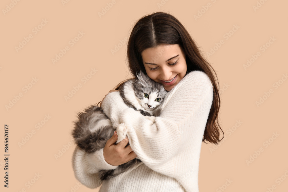 Obraz premium Young woman with longhaired adorable cat on beige background