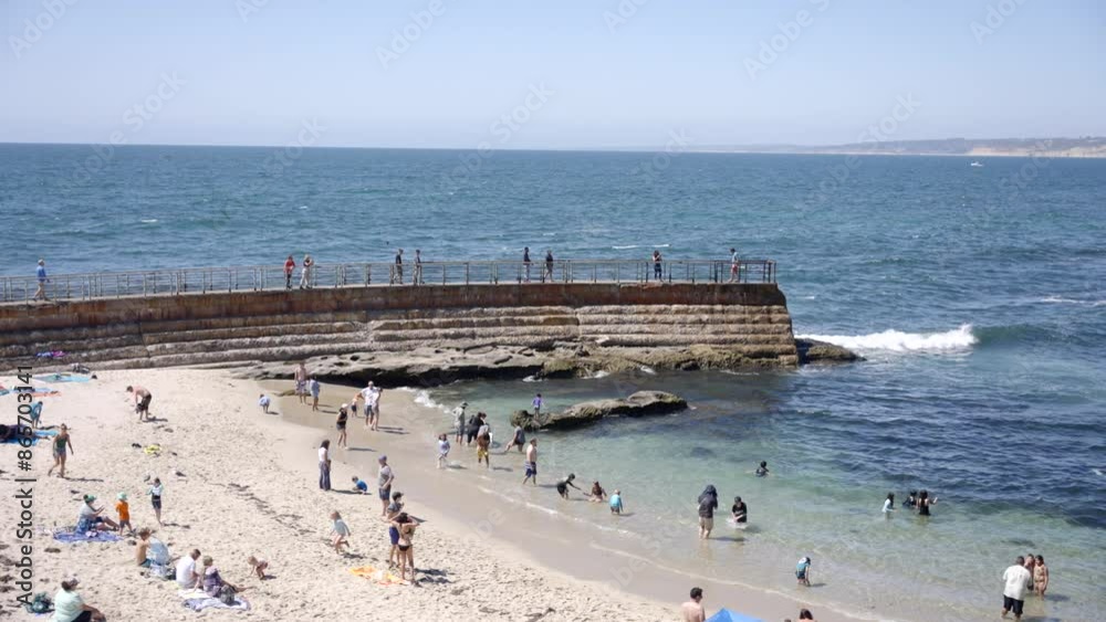 The childrens pool in La Jolla California on a sunny day with tourists enjoying the great weather and Pacific Ocean The childrens pool in La Jolla California on a sunny day with tourists enjoying the great weather and Pacific Ocean