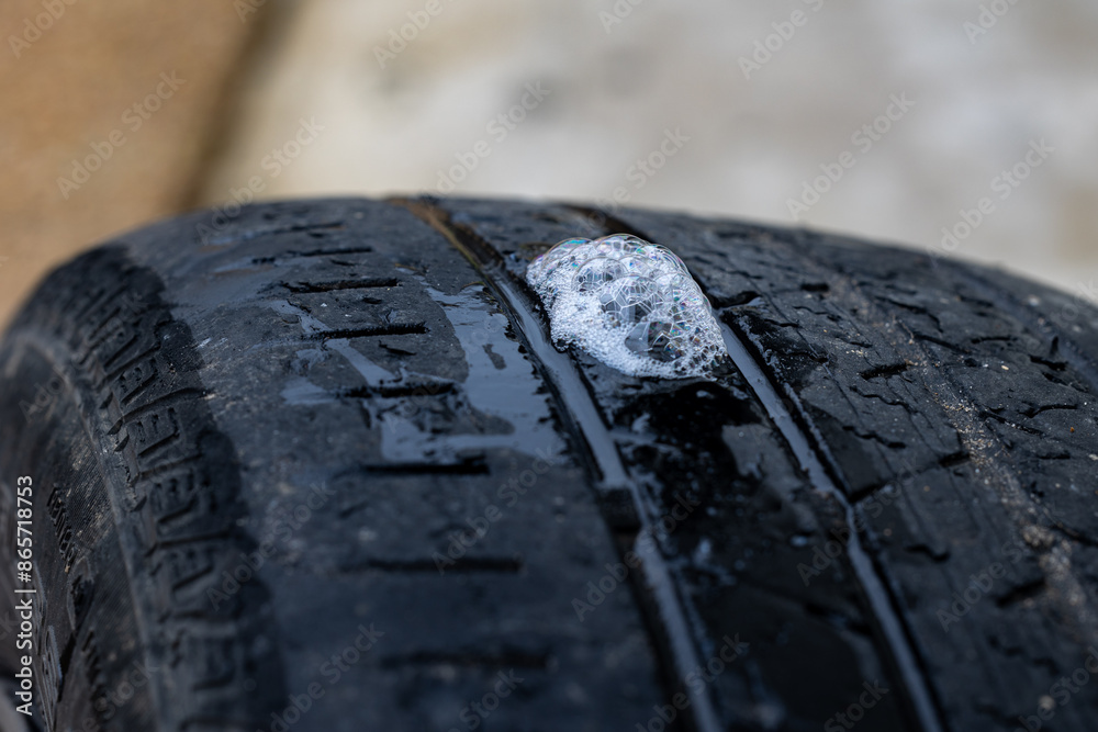 soapy water and bubbles used to find a hole in a flat tire soapy water and bubbles used to find a hole in a flat tire
