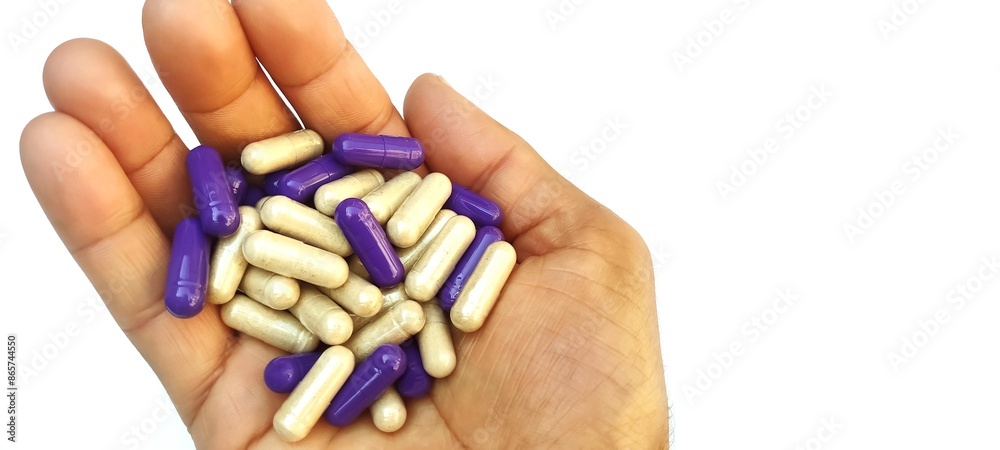 Obraz premium A full hand of pills and capsules on the white background with copy space 