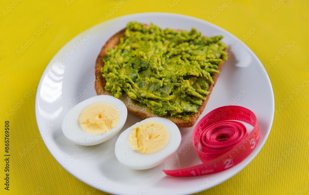 Food for weight loss. Egg, avocado, toast, meter. Cooking healthy food at home. Food on a yellow background.
