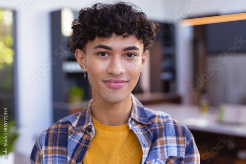 Smiling teenage boy in casual outfit at home, feeling confident