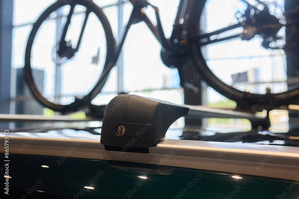 Fototapeta premium A Image Showing a Bicycle Mounted on a Cars Roof Rack in a Sunlit Automobile Showroom