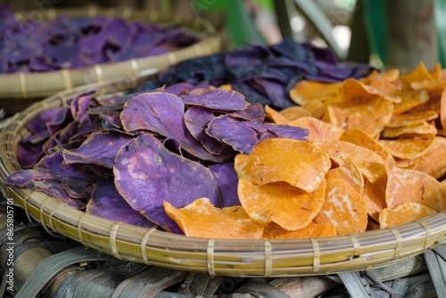 Purple and orange sweet potato chips in bamboo container photo