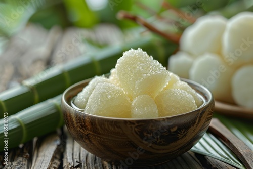 Thai sweet cassava dessert served with coconut milk sugar and pandan leaf photo