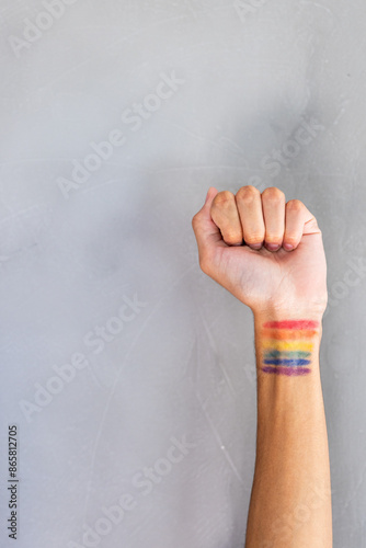 Raising fist, person showing rainbow pride flag tattoo on wrist photo