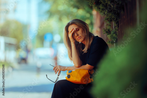 Stressed Woman Suffering a Headache Resting Outdoors. Tired adult person feeling unwell during a hot day
