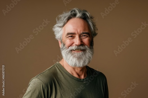 Portrait of a happy senior man with grey beard and mustache. Isolated on brown background.