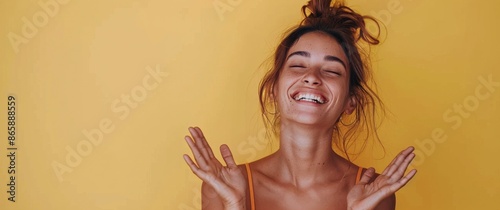 Woman With Brown Hair Laughing In Front Of Yellow Background