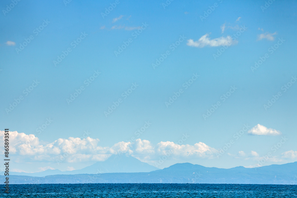 Obraz premium Seascape with a silhouette of a mountain range on the horizon