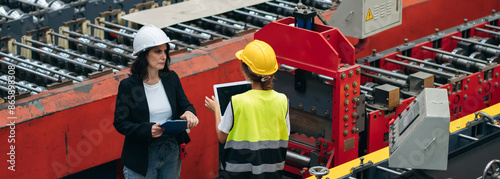 Fotografie Industrial worker inspecting and check up machine at factory machines