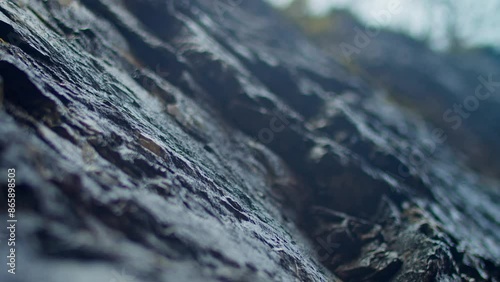 Closeup droplets dripping and flowing on the surface of the rock