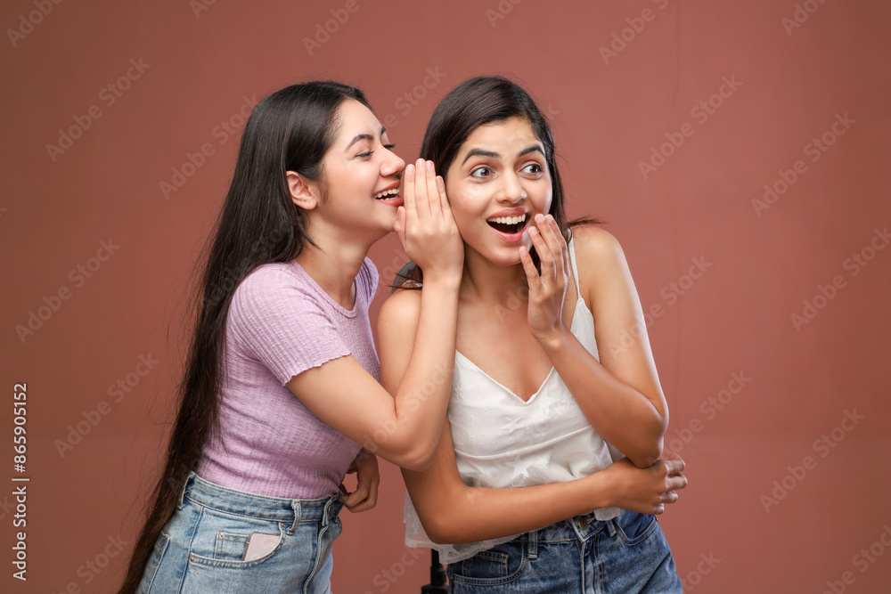 Two Happy Girlfriends Whispering On Ear A Secret Standing In The Studio