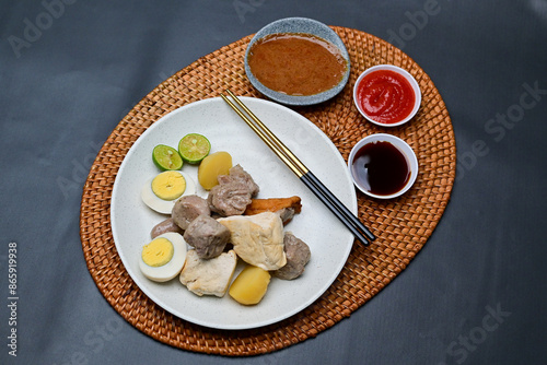 Siomay, a traditional Bandung dish, is a steamed dumpling made from mackerel fish and flour. It’s served with a rich peanut sauce, soy sauce, and chili sauce, offering a flavorful Indonesian culinary 