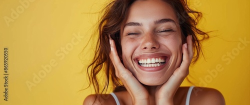 Woman With Brown Hair Laughing In Front Of Yellow Background