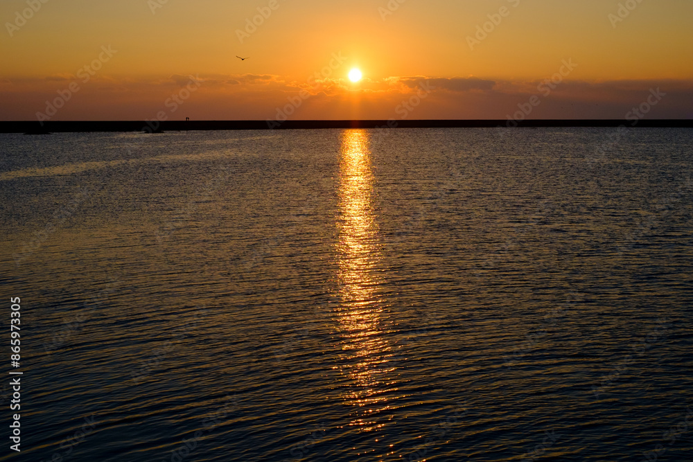 Golden Sunset Reflecting on Calm Ocean Waters Golden Sunset Reflecting on Calm Ocean Waters