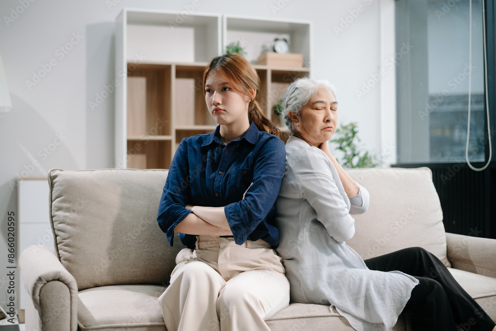 Mother and Daughter in Serious Disagreement emotional tension in silence on sofa at home, stressed after quarrel, ignoring each other Mother and Daughter in Serious Disagreement emotional tension in silence on sofa at home, stressed after quarrel, ignoring each other