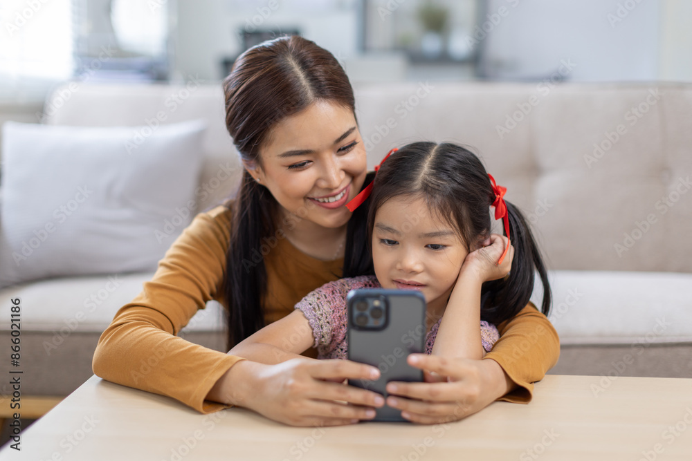 image of mother and daughter cuddling on the sofa using mobile phone waching movie online, image of mother and daughter cuddling on the sofa using mobile phone waching movie online,