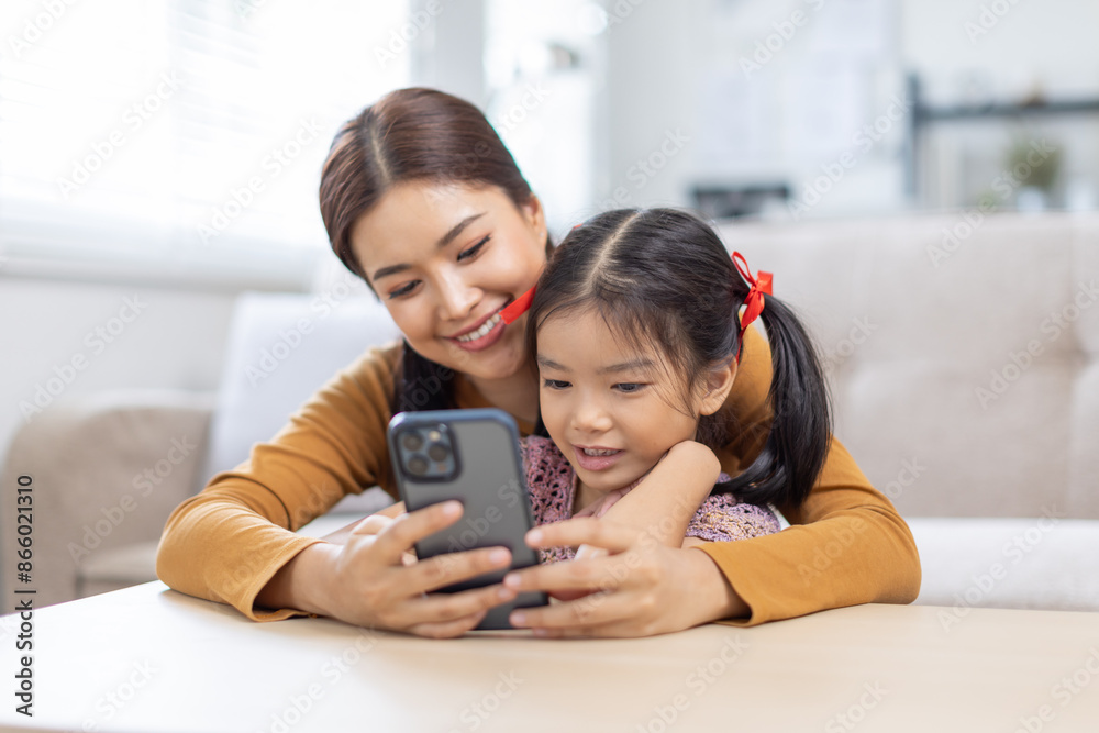 image of mother and daughter cuddling on the sofa using mobile phone waching movie online, image of mother and daughter cuddling on the sofa using mobile phone waching movie online,