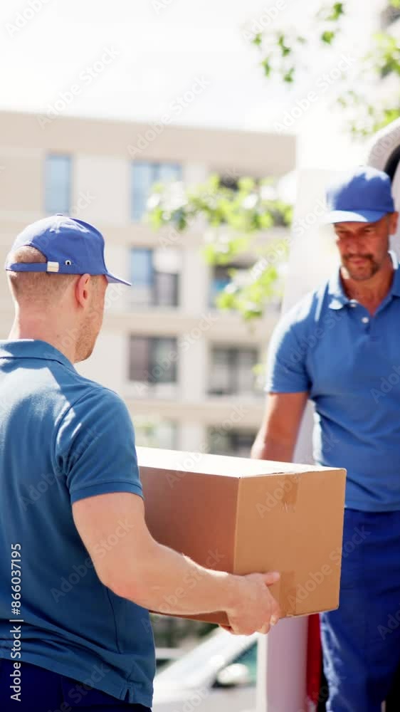 Male Movers Efficiently Loading Cardboard Boxes Into Van - Professional Male Movers Efficiently Loading Cardboard Boxes Into Van - Professional