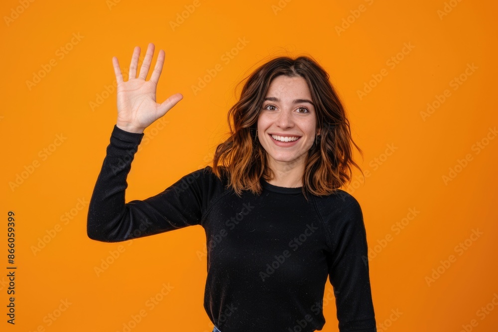 Waving Hello! Adorable Woman with Toothysmile Waving Hand. Happy Indoor Studio Shot
