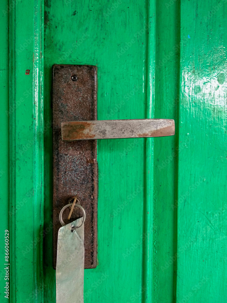 rusty door handle of green door, with key on it rusty door handle of green door, with key on it