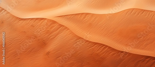 A mesmerizing aerial shot captures a vibrant red sand dune from above, showcasing the textured desert landscape in a top-down vertical view for a holiday vacation concept with copy space image.