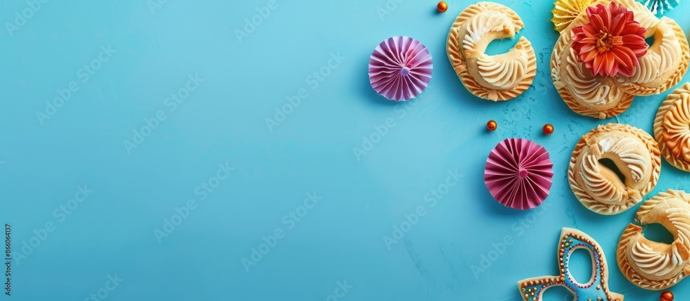 Top-down view of a Jewish Purim celebration theme with a blue backdrop, showcasing hamantaschen cookies and a mask, ideal for copy space images. Top-down view of a Jewish Purim celebration theme with a blue backdrop, showcasing hamantaschen cookies and a mask, ideal for copy space images.