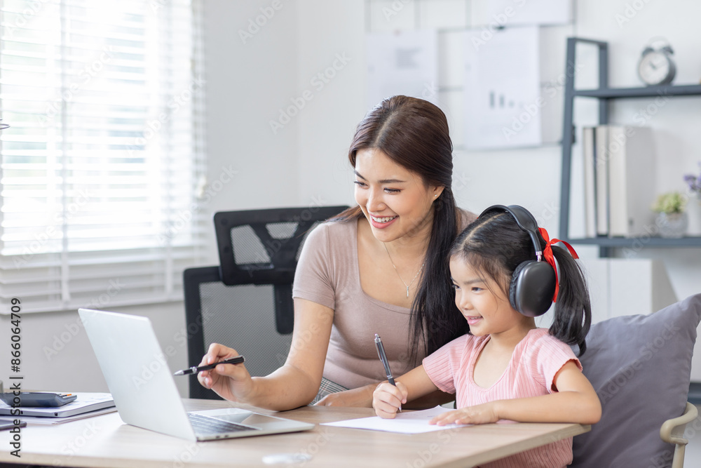 Asian business lady working on computer while her daughter hugging her Asian business lady working on computer while her daughter hugging her