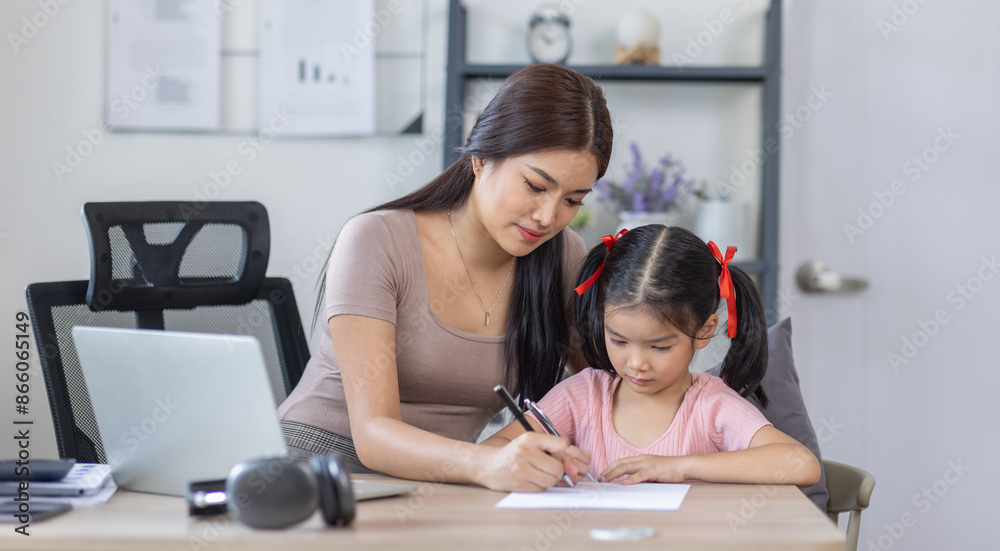 Asian business lady working on computer while her daughter hugging her Asian business lady working on computer while her daughter hugging her