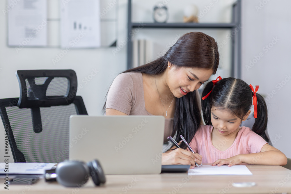 Asian business lady working on computer while her daughter hugging her Asian business lady working on computer while her daughter hugging her