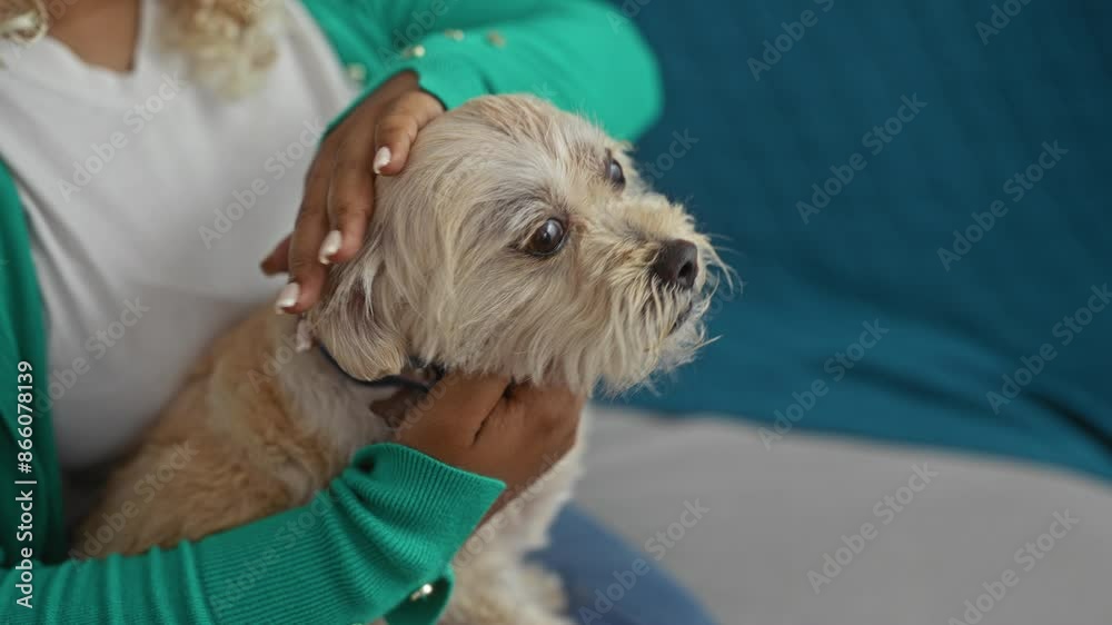 A young african american woman is indoors holding her pet dog close in a cozy home setting, exuding warmth and companionship. A young african american woman is indoors holding her pet dog close in a cozy home setting, exuding warmth and companionship.