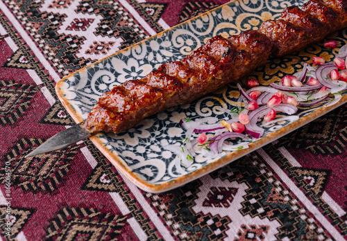 Savory grilled kebab on ornate ceramic plate