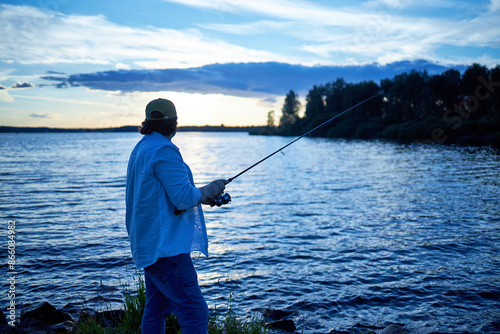 a fisherman catches a fish on a river on a summer day