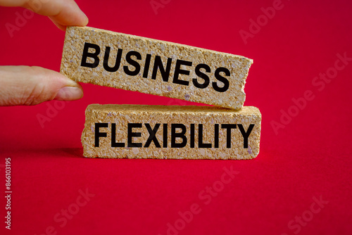 Business flexibility symbol. Concept words Business flexibility on brick blocks. Beautiful red background, businessman hand. Business flexibility concept.