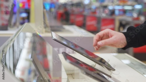 White male hand holding a stylus for a digital tablet in electronics store