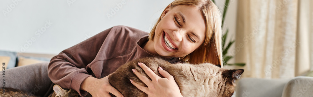 A serene woman with short hair sitting on a couch, tenderly holding and cuddling her beloved cat. A serene woman with short hair sitting on a couch, tenderly holding and cuddling her beloved cat.