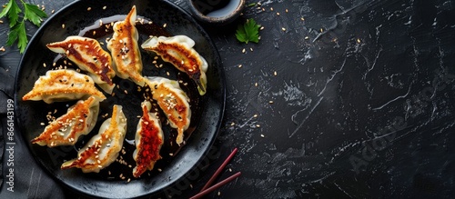 Gluten-free gyozas with sauce on a black table in a Japanese restaurant, with copy space image. photo