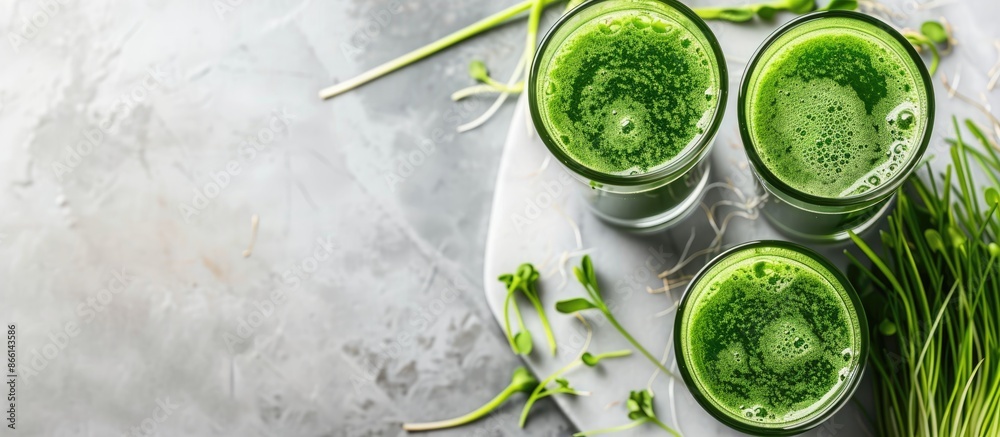 A marble table showcasing glasses of wheatgrass juice with green sprouts, offering ample room for text in the image. A marble table showcasing glasses of wheatgrass juice with green sprouts, offering ample room for text in the image.