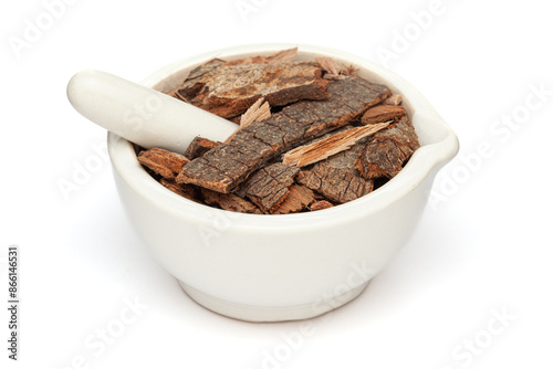 Close-up of Dry Organic Banyan or Banian (Ficus benghalensis) tree barks, in white ceramic mortar and pestle, isolated on a white background. photo