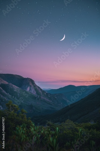 The moon rising over a mountain range, with a softly blurred background of a twilight sky and stars. 