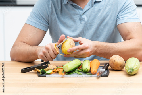 Close-up shot of a man peeling vegetables using special vegetable peelers in the kitchen	 photo