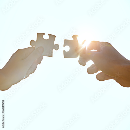 Hands, sky and people fitting puzzle pieces together outdoor from below for synergy or team building. Assemble, partnership or teamwork with inclusion and business jigsaw for connection or solidarity