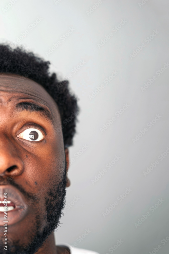 African American man with surprised expression, closeup portrait against light background African American man with surprised expression, closeup portrait against light background
